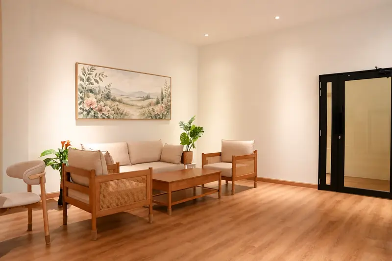 Avida visitor lounge with wood and rattan seating and a warm framed painting